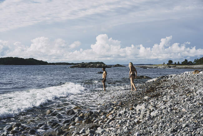 Coppia in costume da bagno passeggiando sulla riva del fiume — Foto stock