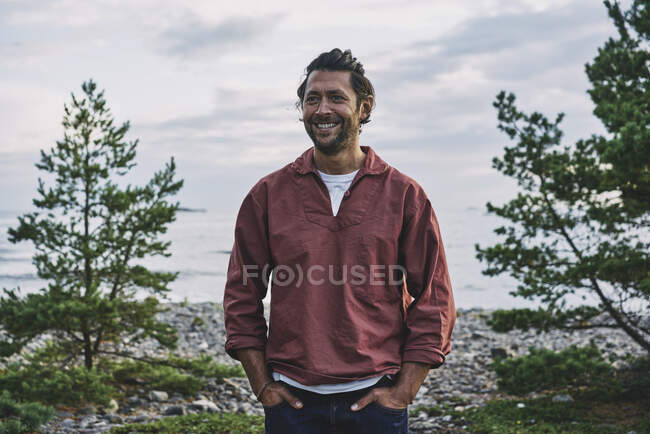Uomo in giacca rossa in piedi sul lago — Foto stock