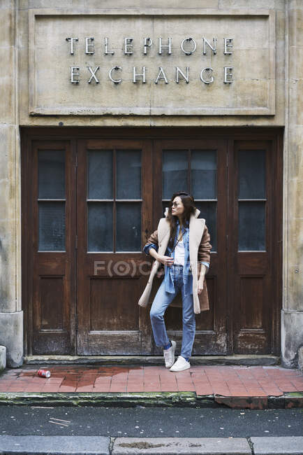 Femme debout près des portes sur le sentier de la ville — Photo de stock