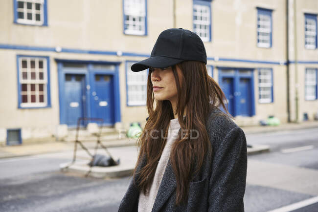 Donna col berretto da baseball che cammina per strada — Foto stock