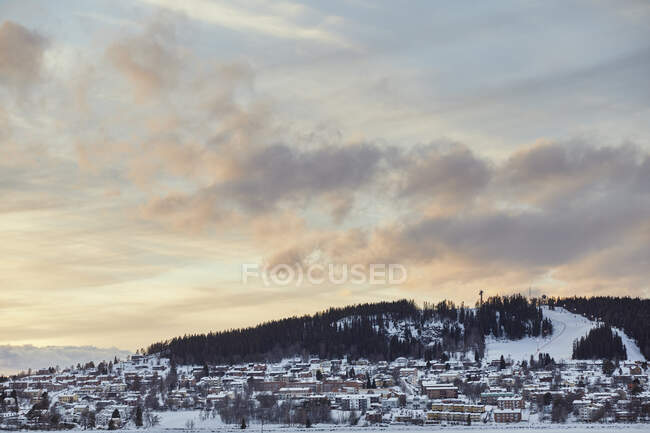 Neige sur le paysage urbain et la station de ski au coucher du soleil — Photo de stock