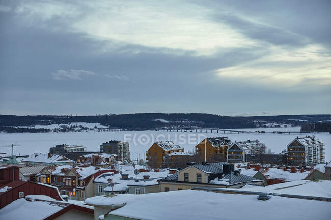 Buildings by frozen lake in winter — Stock Photo