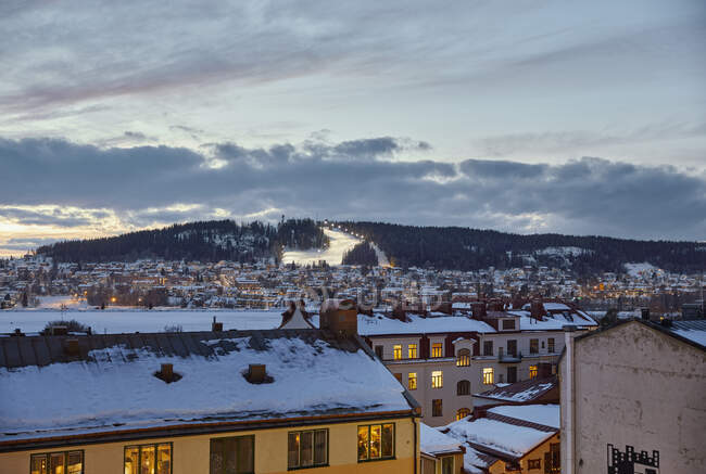 Neve na paisagem urbana e estância de esqui durante o pôr do sol — Fotografia de Stock