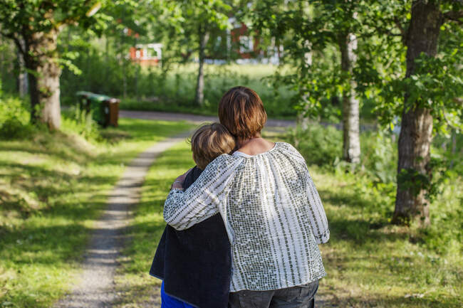 Grandmother hugging her grandson by rural road — Stock Photo
