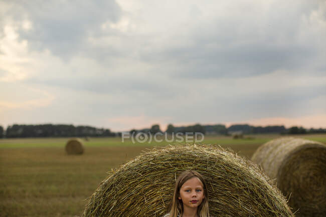 Дівчина на тюку на фермі — стокове фото