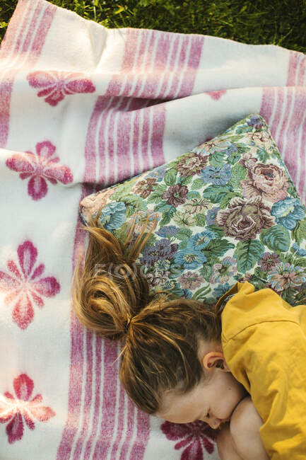 Девушка спит на одеяле для пикника — стоковое фото