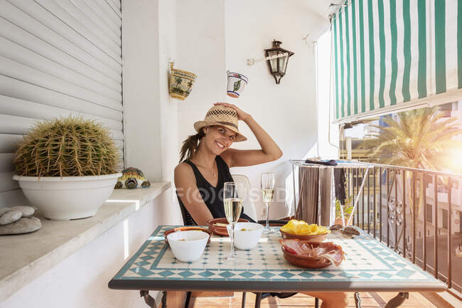 Mulher adulta média sentada à mesa na varanda — Fotografia de Stock