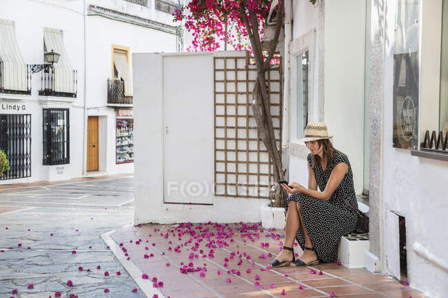 Жінка пише повідомлення, сидячи на ногах. — стокове фото