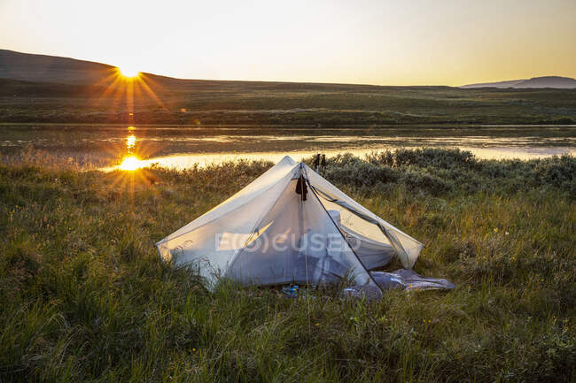 Tente près des collines pendant le coucher du soleil — Photo de stock