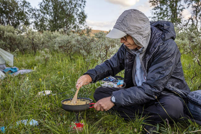 Homme cuisine sur le poêle de camping — Photo de stock