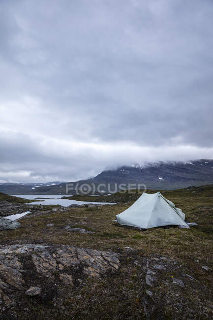 Палатка у озера и гор — стоковое фото