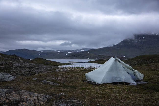 Палатка у озера и гор — стоковое фото
