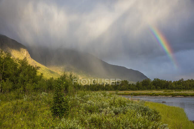 Arco iris y nubes sobre la montaña - foto de stock