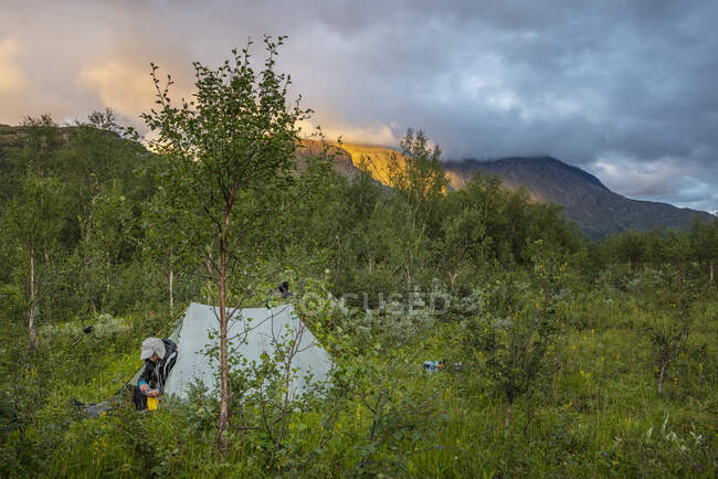 Человек сидит в палатке во время похода — стоковое фото
