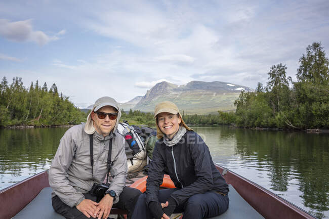 Casal sentado em canoa no lago — Fotografia de Stock