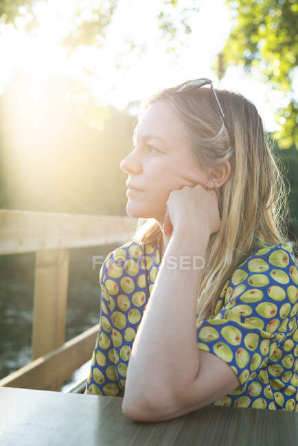 Женщина сидит и думает на солнышке — стоковое фото