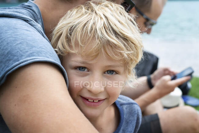 Portrait of smiling boy sitting with family — Stock Photo