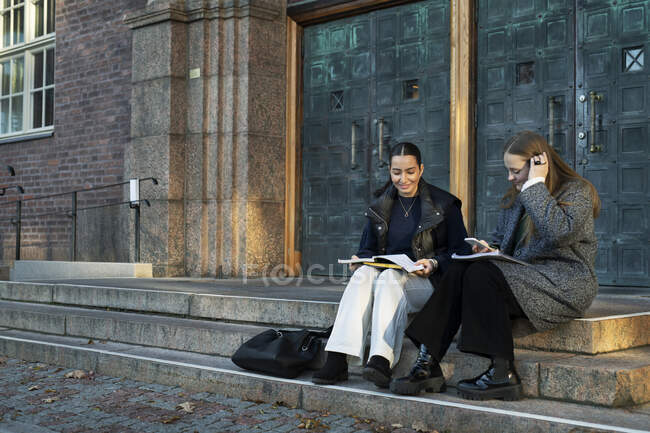 Young women studying on steps — Stock Photo