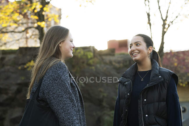 Молодые женщины разговаривают на городской улице — стоковое фото
