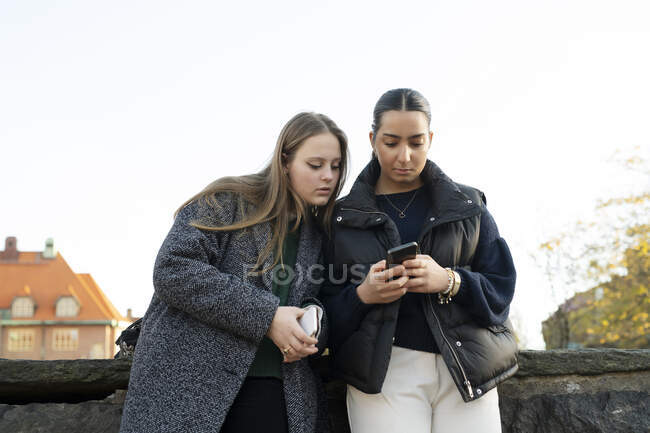 Jovens mulheres usando telefone inteligente — Fotografia de Stock