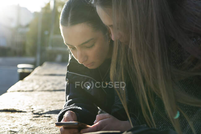 Mujeres jóvenes utilizando el teléfono inteligente - foto de stock