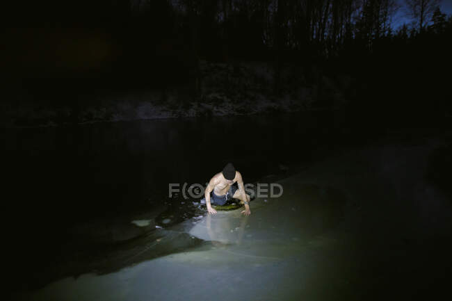 Man swimming in frozen lake — Stock Photo