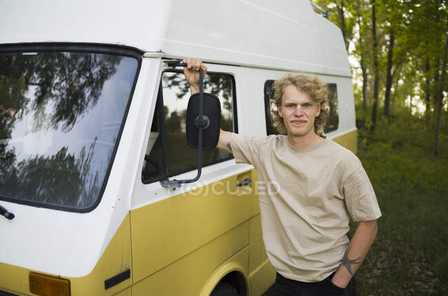 Homem apoiado em van na floresta — Fotografia de Stock