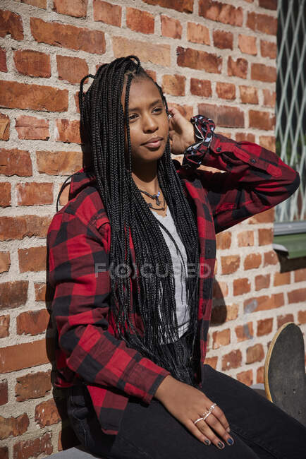 Adolescente appuyée sur un mur de briques — Photo de stock