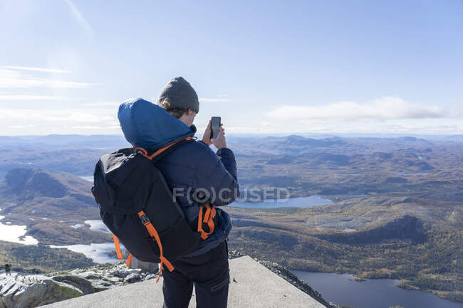 Giovane uomo scattare foto in montagna — Foto stock