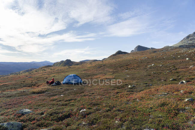 Man with tent camping on mountain — Stock Photo