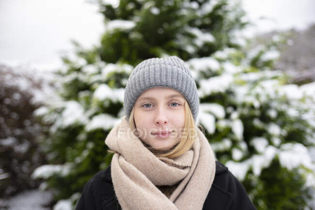 Portrait of teenage girl and tree in snow — Stock Photo