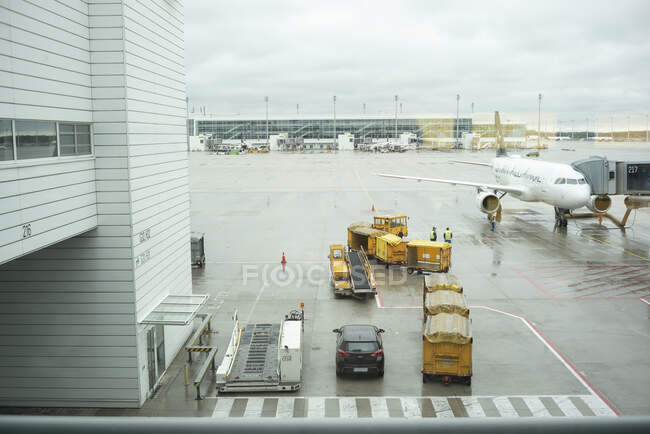 Baggage car and airplane at airport — Stock Photo