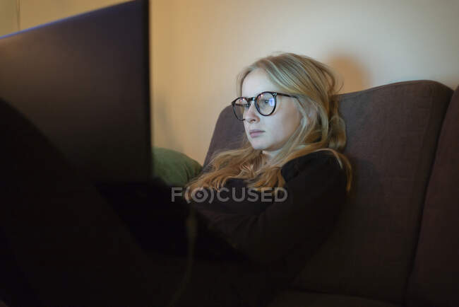 Adolescente com óculos usando laptop — Fotografia de Stock