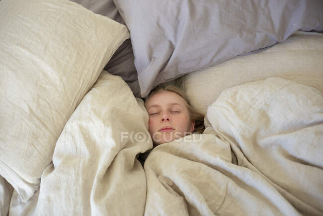 Teenage girl sleeping in bed — Stockfoto