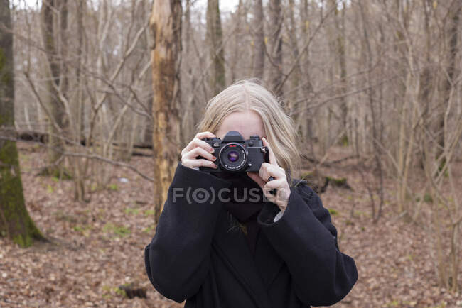 Chica adolescente tomando fotografías en el bosque - foto de stock
