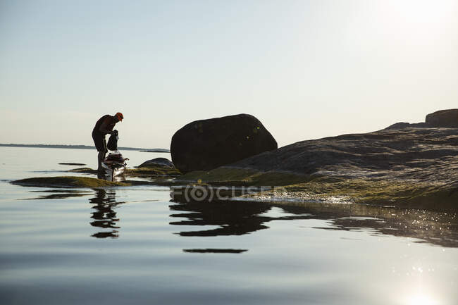 Hombre acampando en rocas costeras - foto de stock