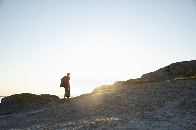 Чоловік ходить на узбережжі під час заходу сонця — стокове фото