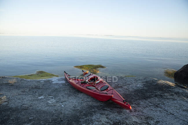 Red kayaks on rocks by sea — Stock Photo