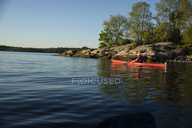 Hombre en chaleco salvavidas kayak en el mar - foto de stock