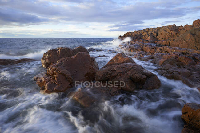 Olas en las rocas en la costa - foto de stock
