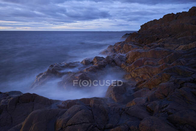 Ondas em rochas na costa — Fotografia de Stock