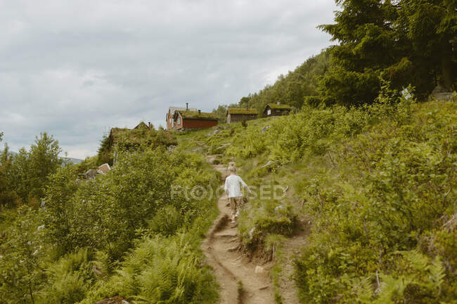Mädchen wandert auf Weg zur Hütte — Stockfoto