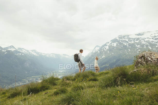 Padre e hija haciendo senderismo en montaña - foto de stock