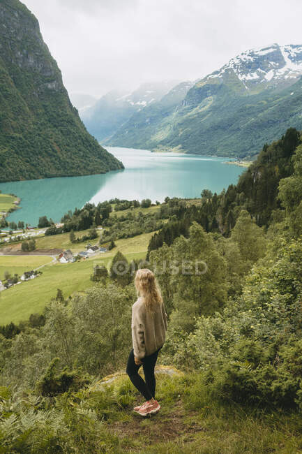 Menina de pé na montanha por lago — Fotografia de Stock