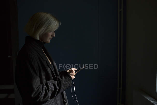 Young woman in blazer text messaging — Stock Photo