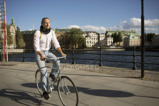 Man riding bicycle by harbour — Stock Photo