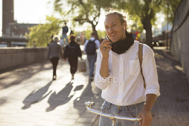 Человек с велосипедом разговаривает по телефону — стоковое фото