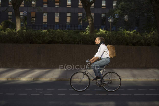 Чоловік їде на велосипеді на міській вулиці — стокове фото
