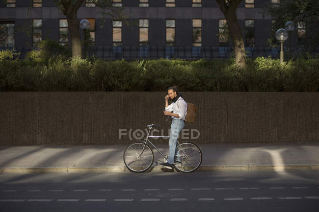 Man listening to music on bicycle — Stock Photo