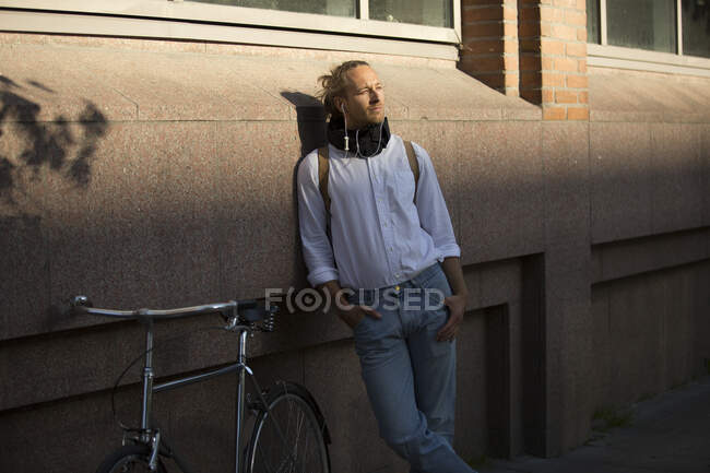 Man listening to music by bicycle — Stock Photo